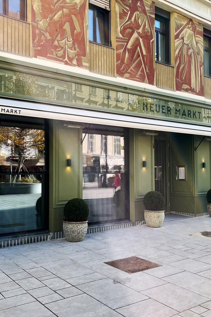 Das Restaurant „Plachutta's Neuer Markt“ in Wien mit grüner Fassade und Außendekoration.