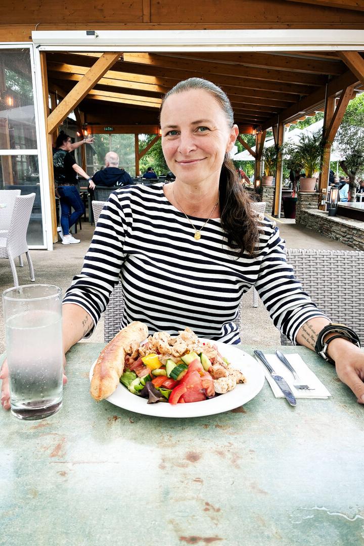 Katharina Nehammer sitzt an einem Tisch, vor sich ein Salat