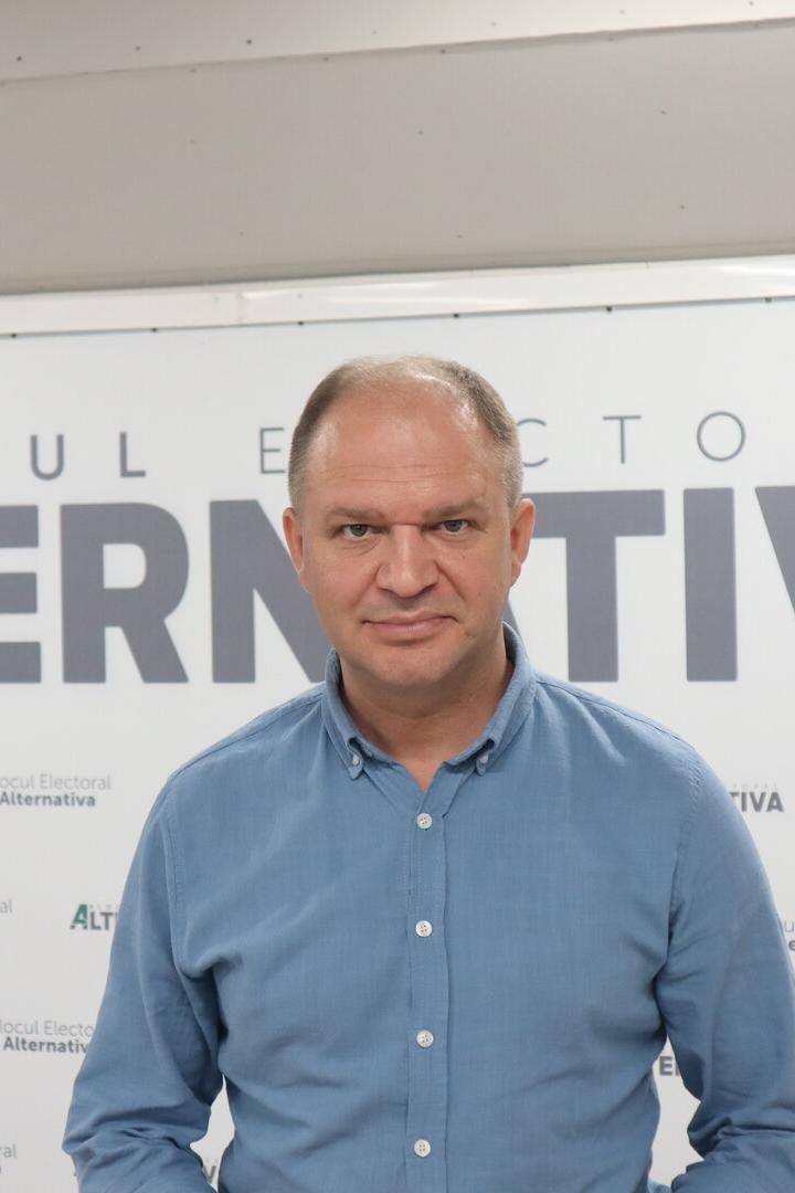 Ein Mann in Hemad steht vor dem Schriftzug "Blocul Electoral Alternativa"