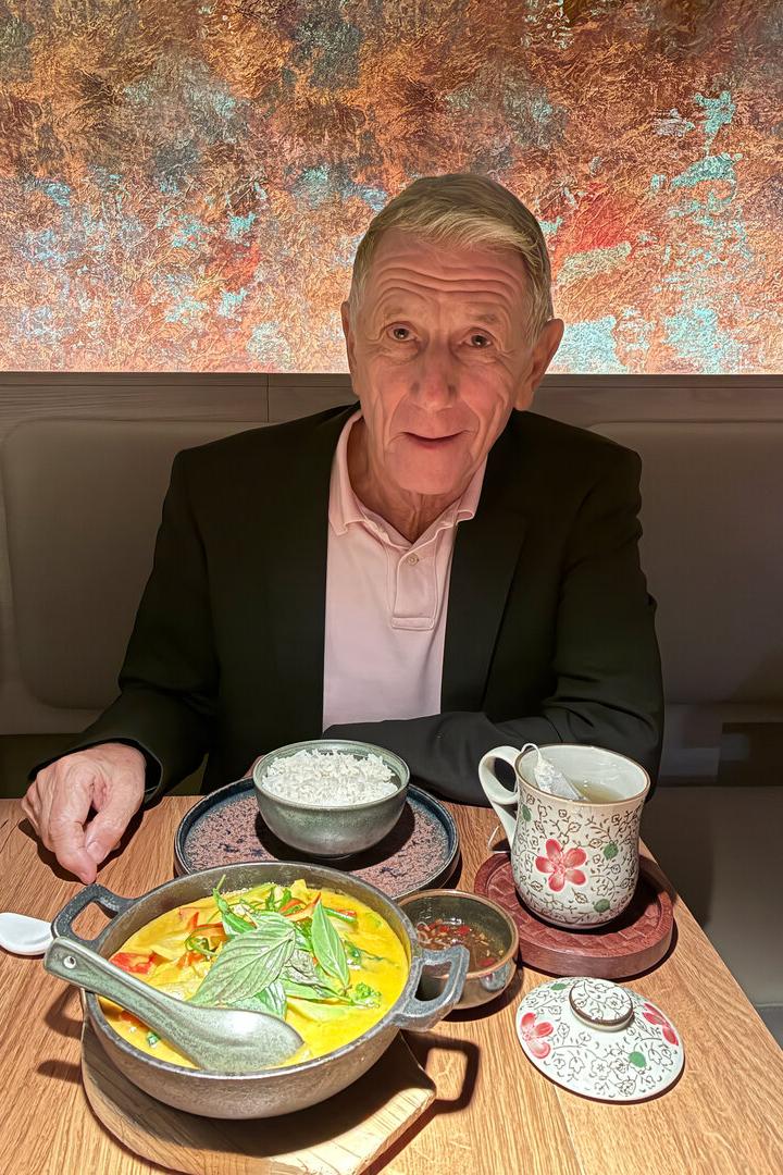 Peter Hochegger, Ex-PR-Manager, trägt Poloshirt und Anzug und sitzt in einem Restaurant vor einer Schüssel Reis und Thai-Curry