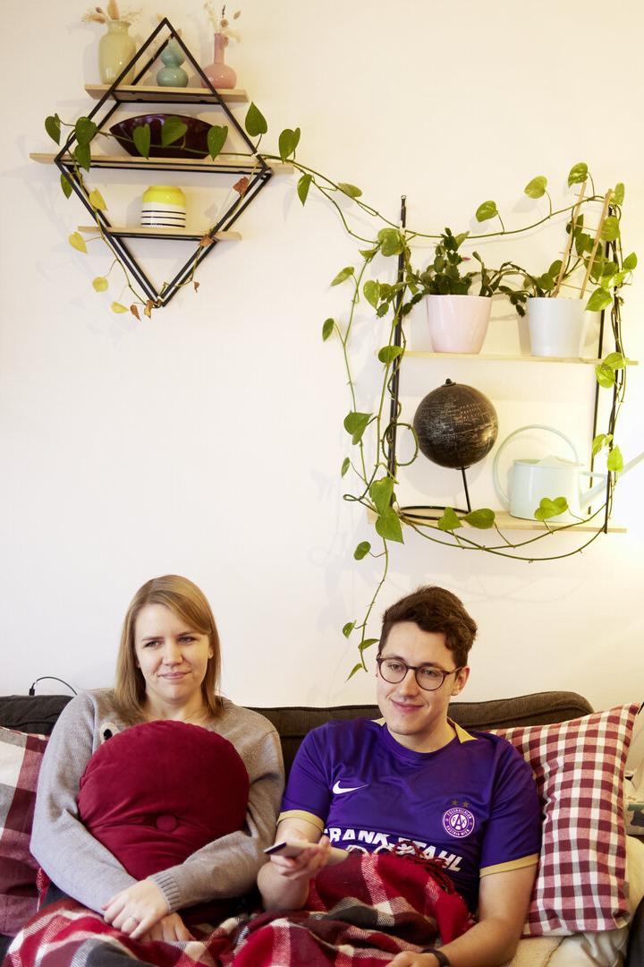 Long-Covid-Betroffene Dini und Lukas auf der Couch im Wohnzimmer