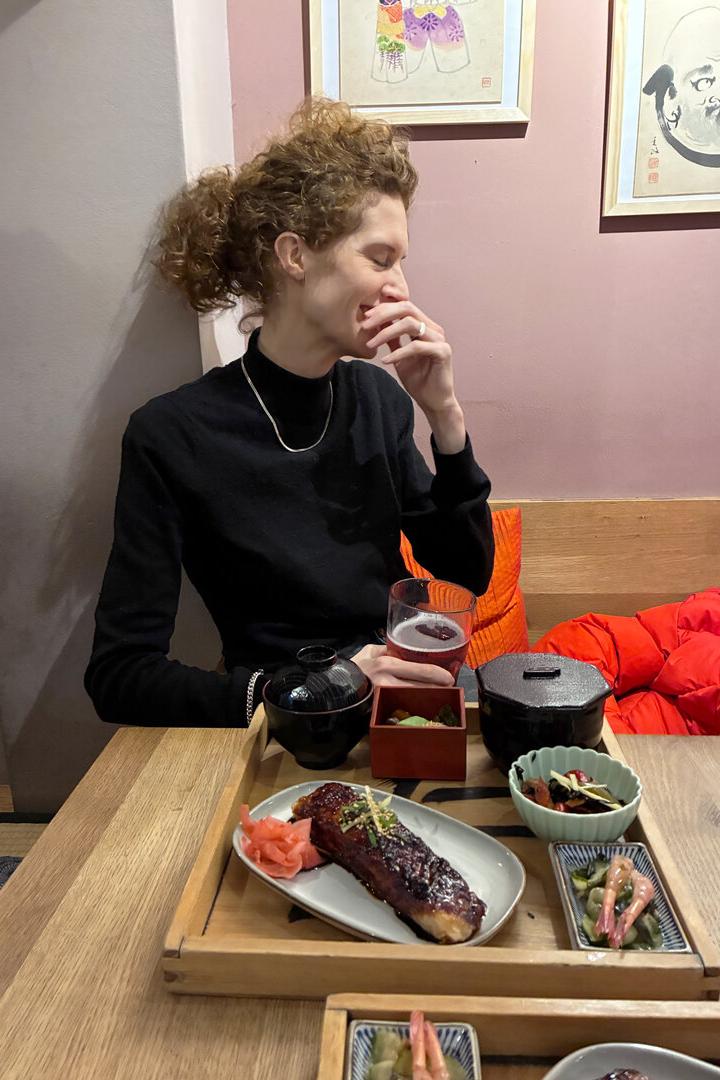 Schauspielerin Julia Riedler sitzt hinter einem japanischen Mittagsteller und blickt zur Seite