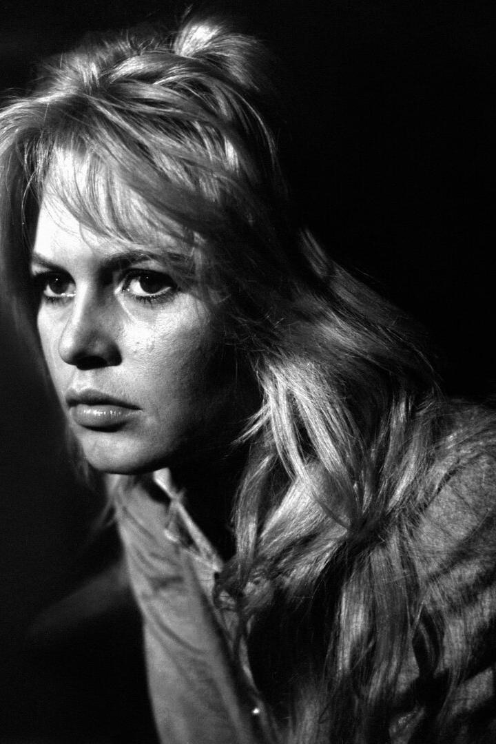 Die junge Brigitte Bardot blickt ernst in einen schwarzen Raum  