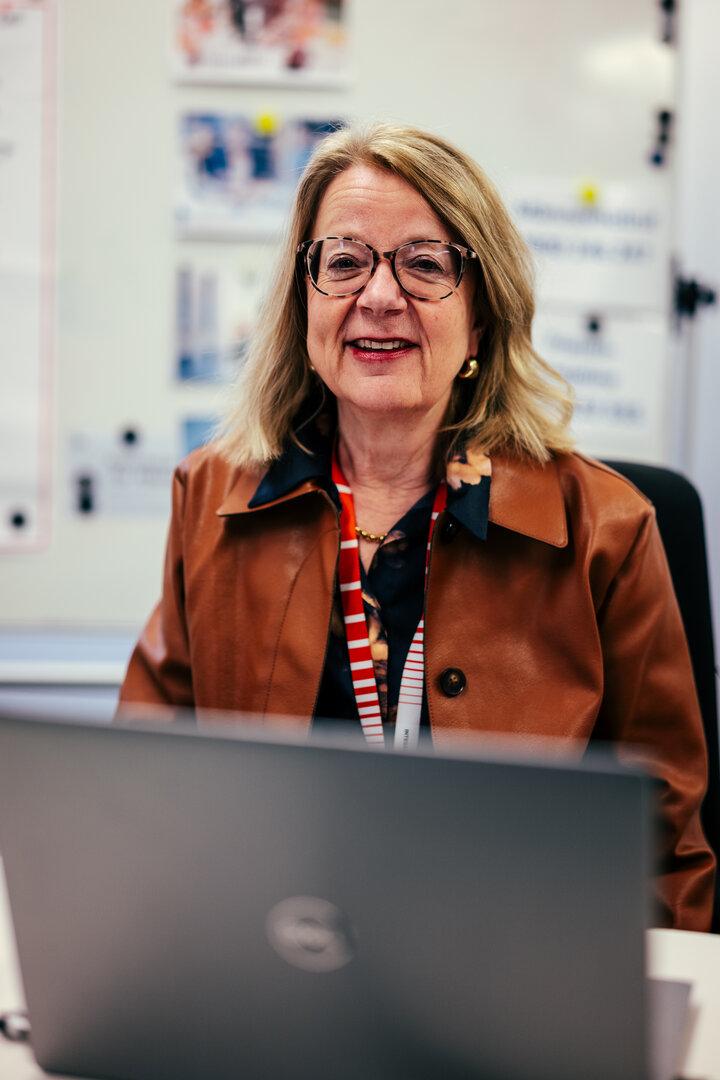 Frau stitzt vor aufgeklapptem Laptop