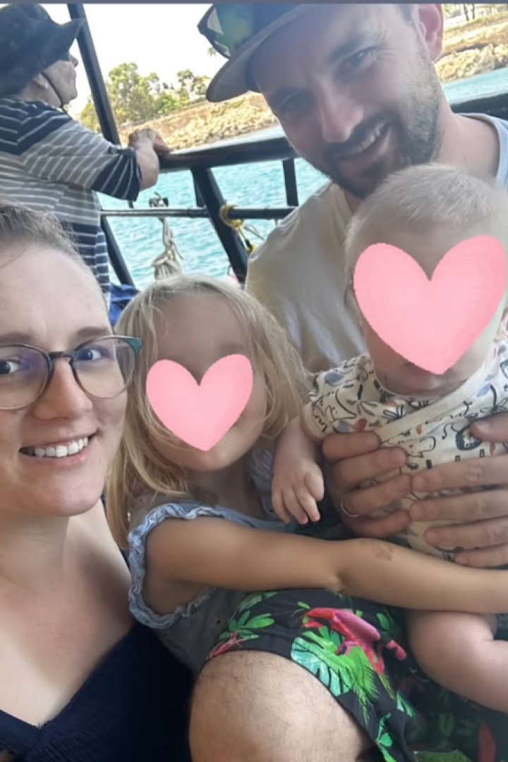 Eine Familie sitzt lächelnd auf einem Boot, zwei Kinder haben Herzen über den Gesichtern.