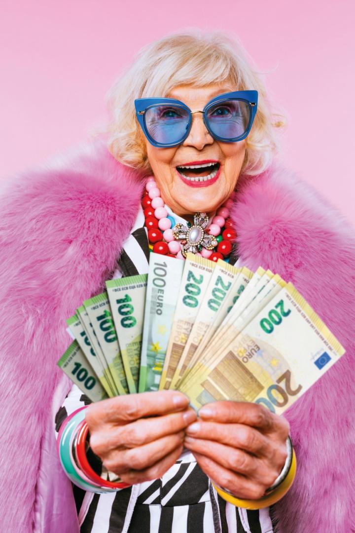 Dame mit rosa Pelzmantel und Geldscheinen in der Hand