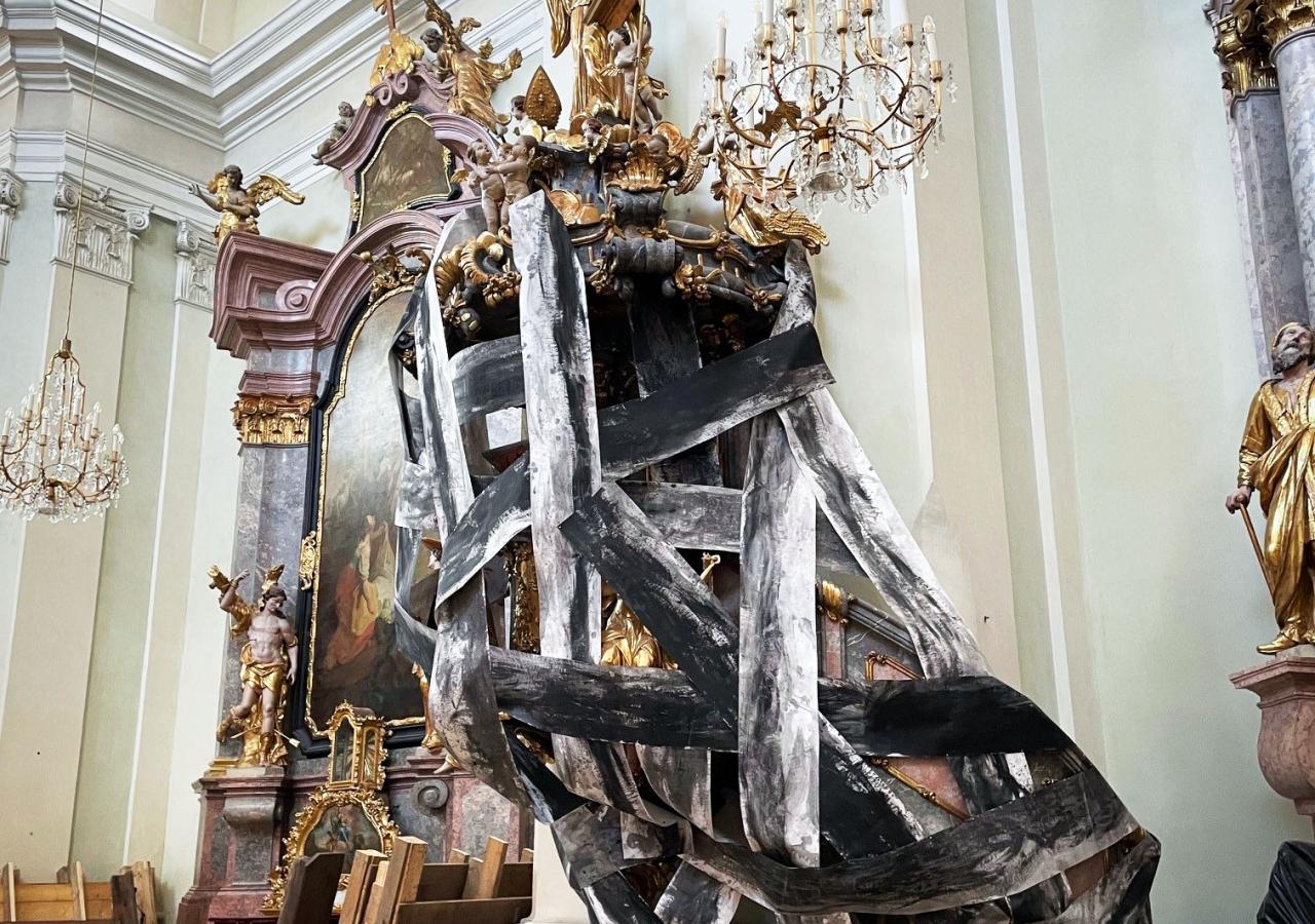 Ein Altar in einer Kirche ist mit Planen verhüllt.