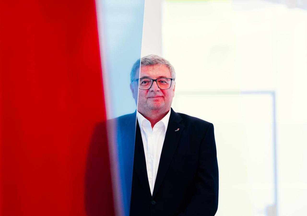 Jörg Leichtfried steht hinter einer roten Plexiglasscheibe 