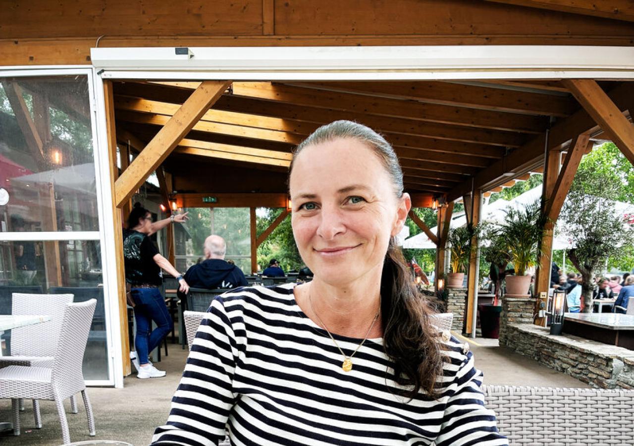 Katharina Nehammer sitzt an einem Tisch, vor sich ein Salat.