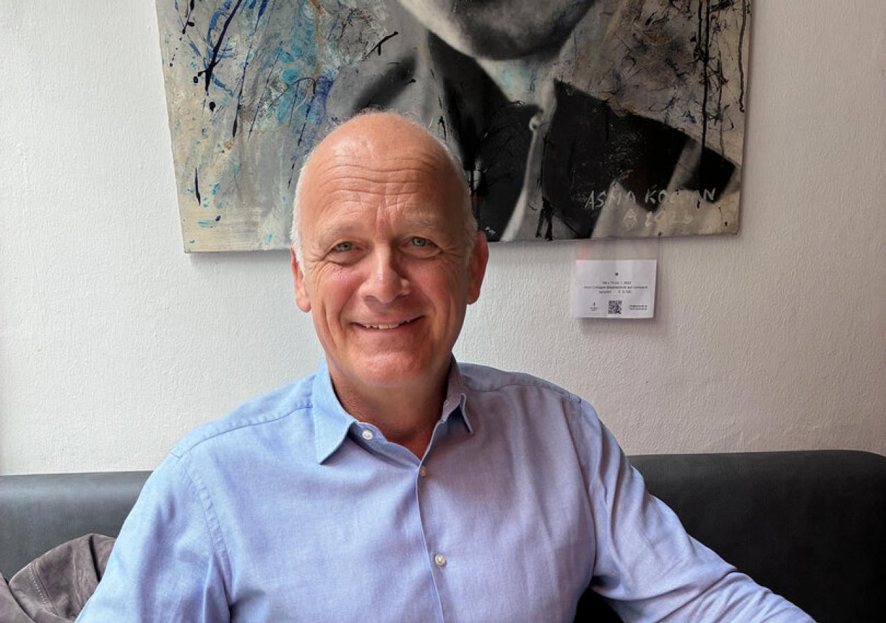 Herwig Straka sitzt in blauem Hemd am Restauranttisch, vor sich ein Rindscarpaccio