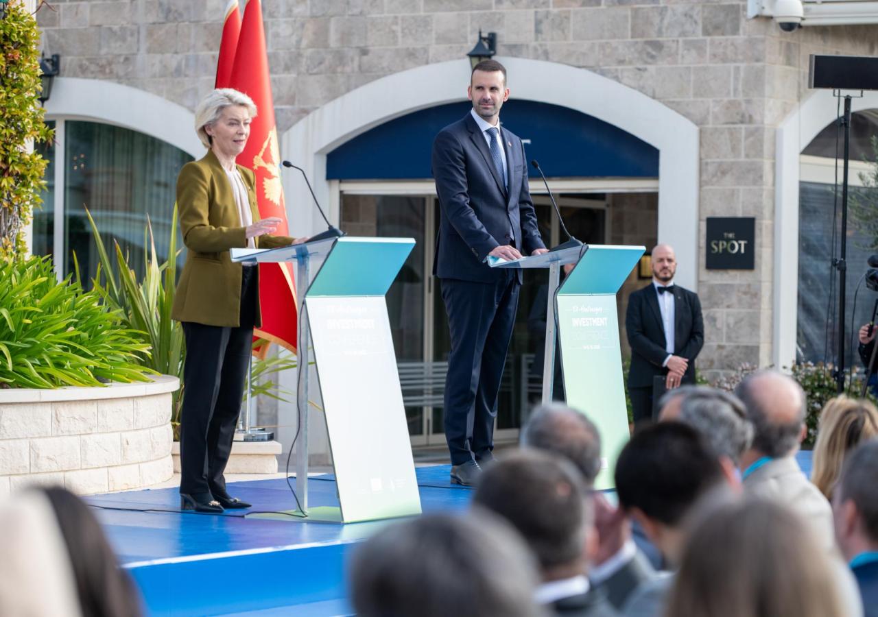 Ursula von der Leyen und  Milojko Spajić (Premier Montenegros) stehen auf einem Podium vor einer Montenegro-Flagge.