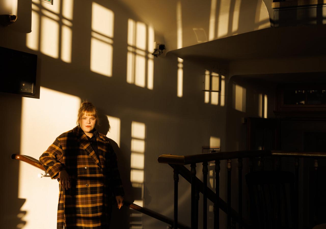 Stefanie Reinsperger steht in einem Treppenhaus