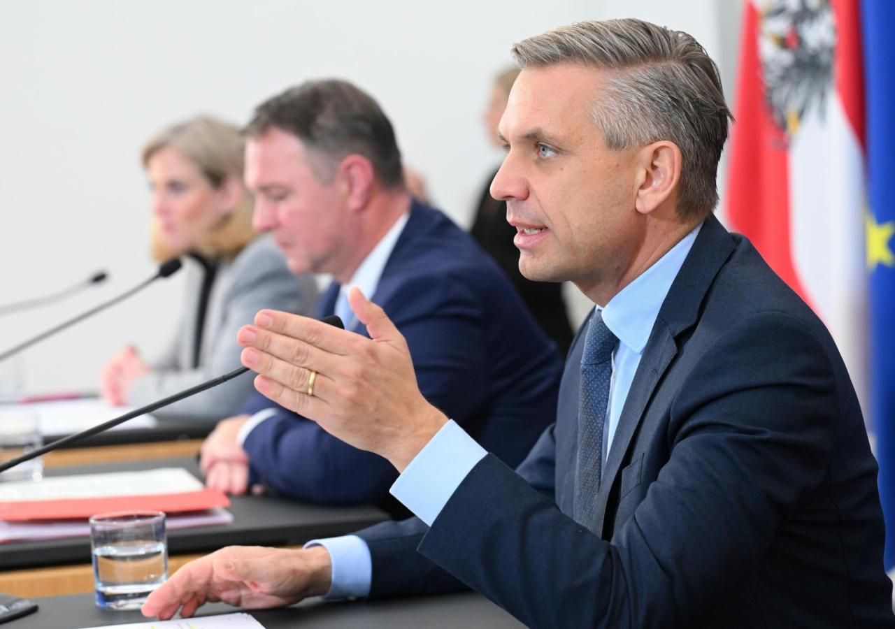 zu sehen ist der ÖVP-Wirtschaftsminister Wolfgang Hattmannsdorfer, hinter ihm Vizekanzler Andreas Babler (SPÖ) und Außenministerin Beate Meinl-Reisinger im Rahmen des Ministerrates