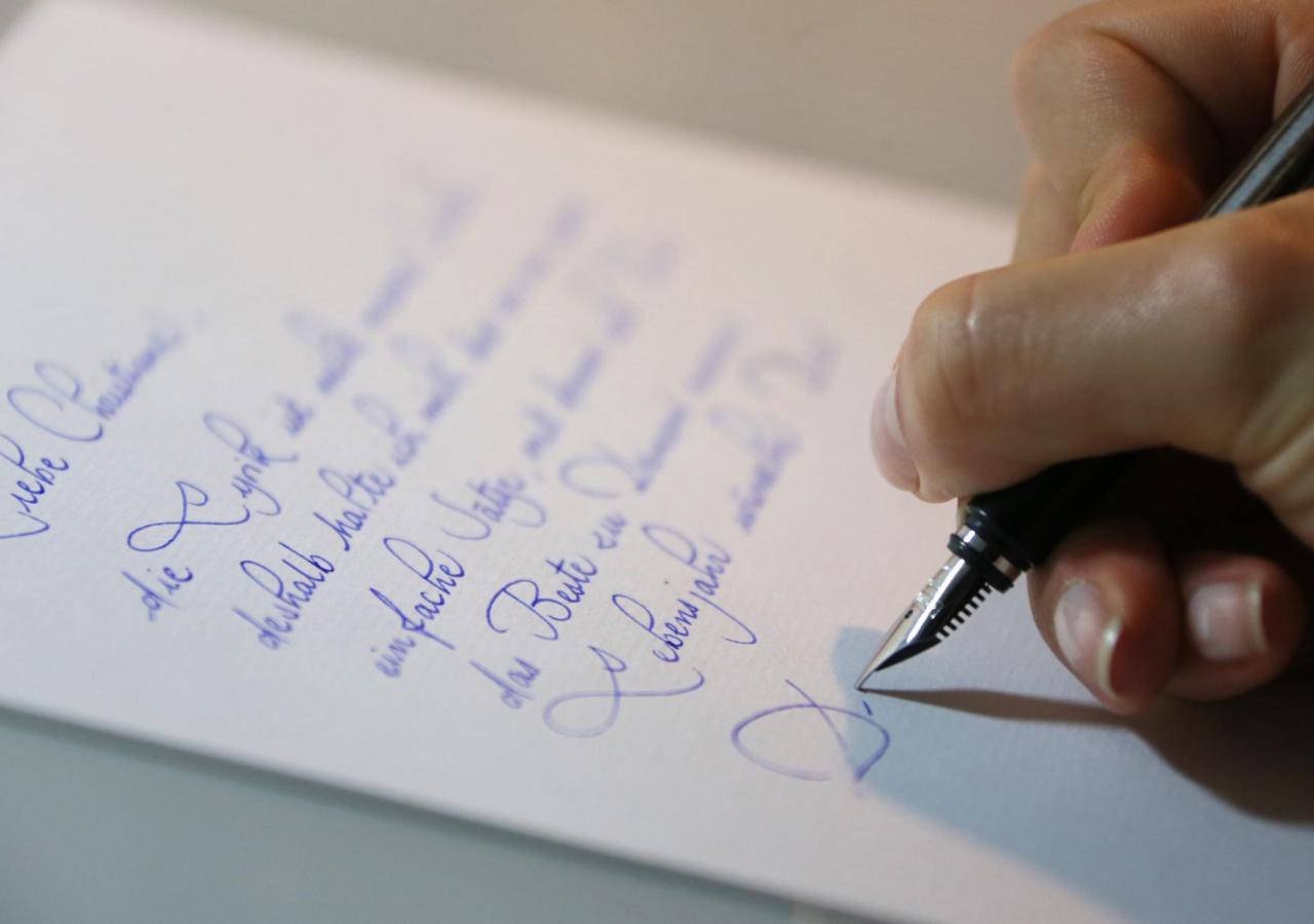 Eine Hand mit Füllfeder schreibt einen Brief