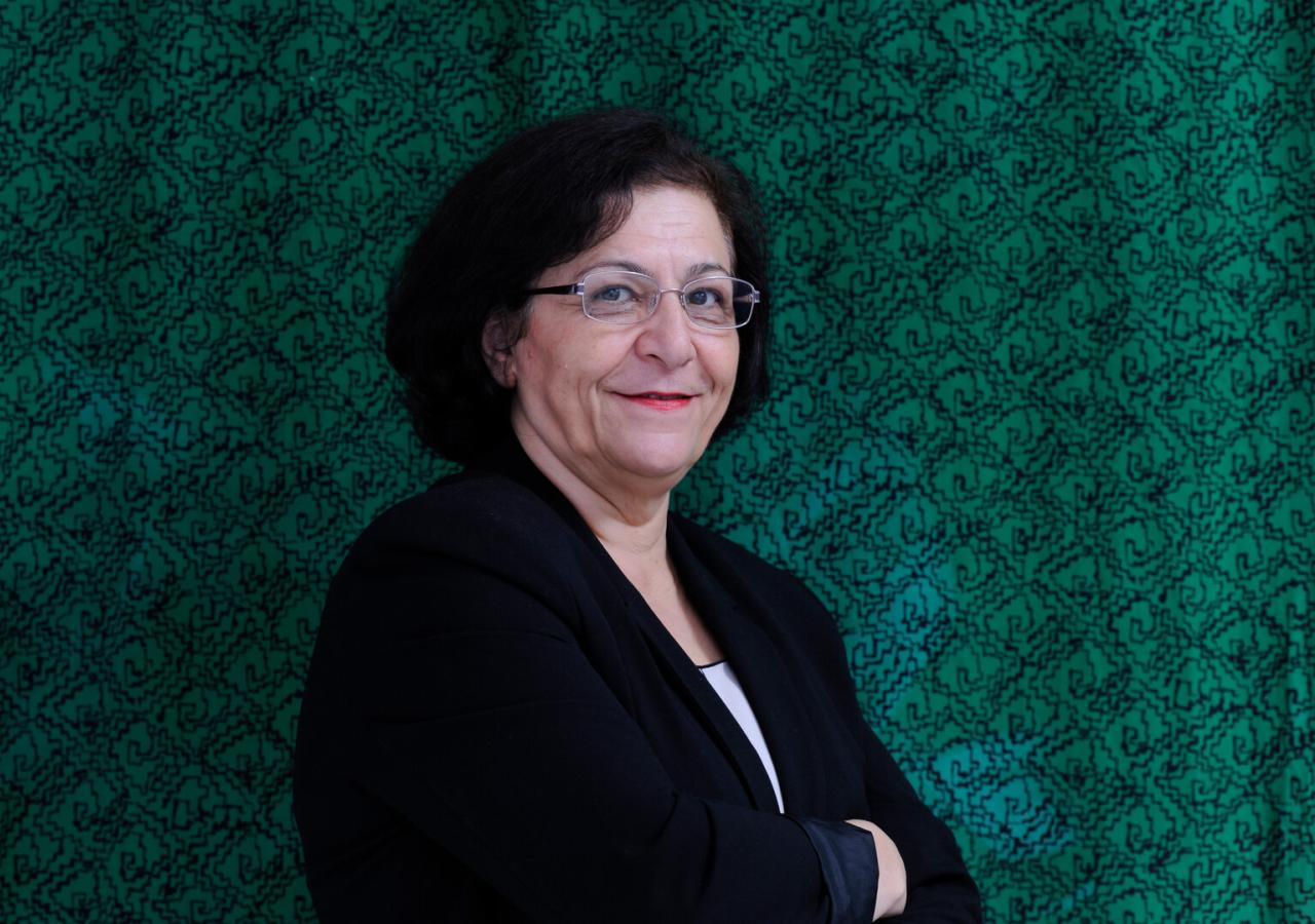 Mina Ahadi steht vor einer grünen Wand.