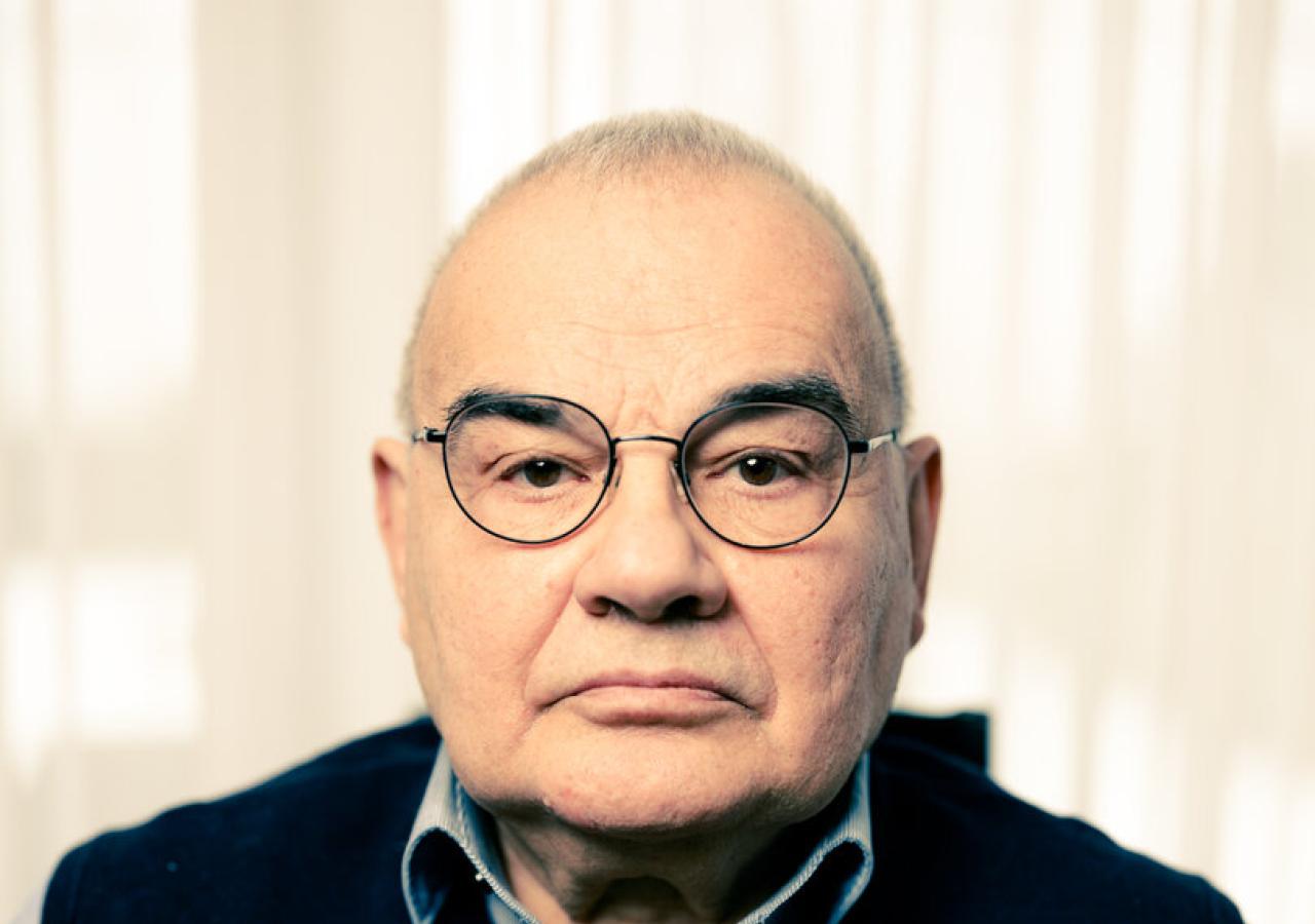 Homayoun Alizadeh in Pulli vor Gardinen