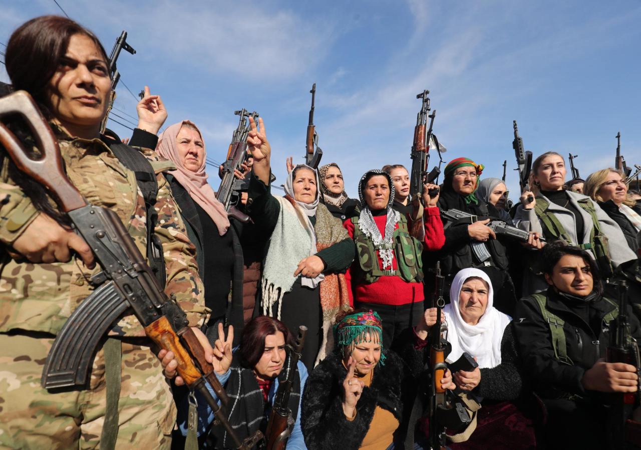 Frauen posieren mit AK-47er. Links ein Frau in Militäruniform.