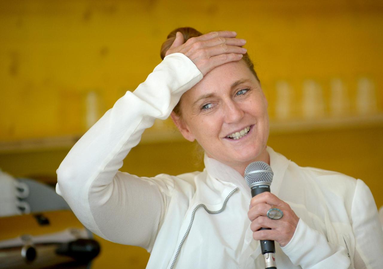 Francesca Thyssen-Bornemisza hält ein Mikro und fässt sch an die Stirn.