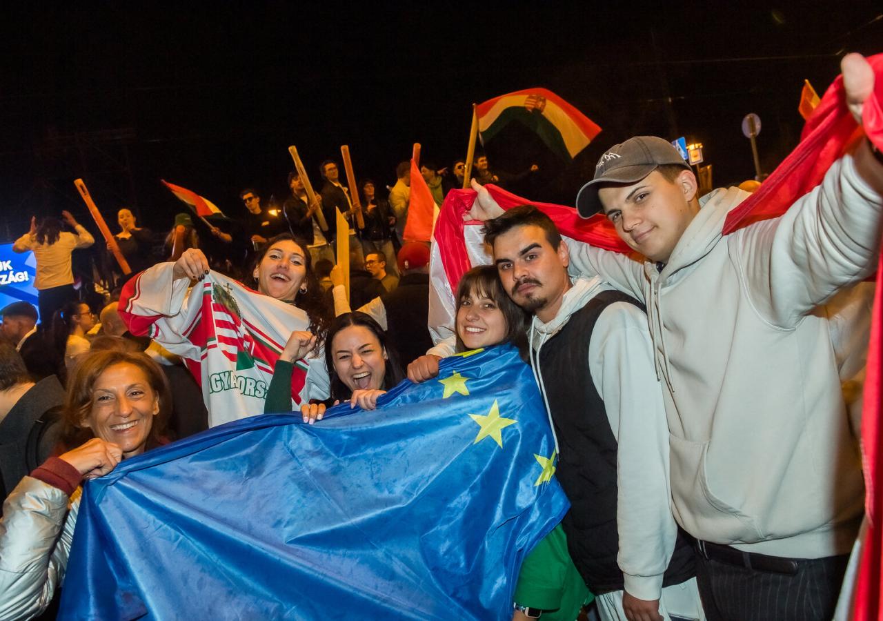 Junge Menschen posieren mit einer EU-Flagge.