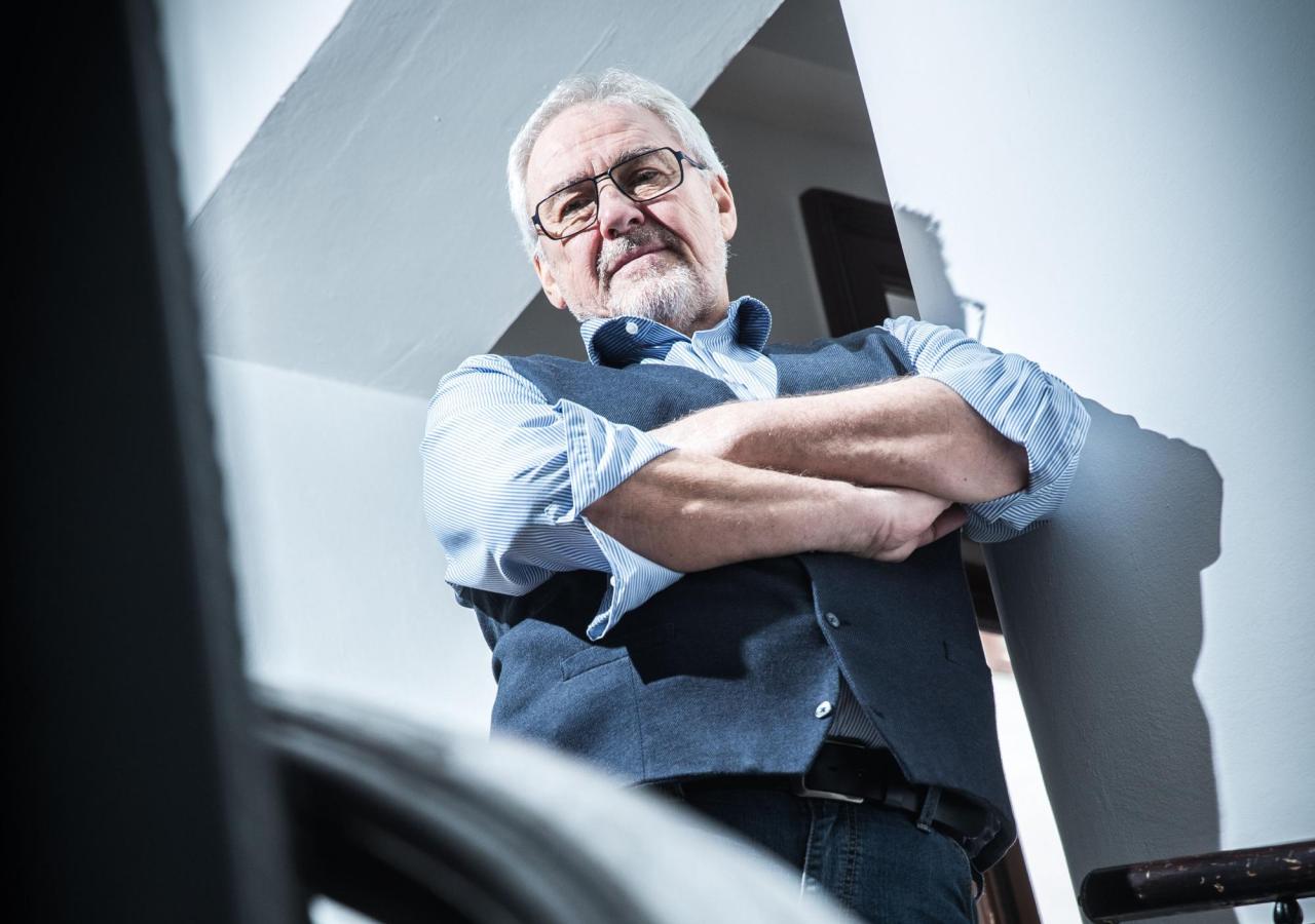 Ein Mann mit Brille und verschränkten Armen, es ist der ORF-Manager Pius Strobl,  steht an einem Treppengeländer.