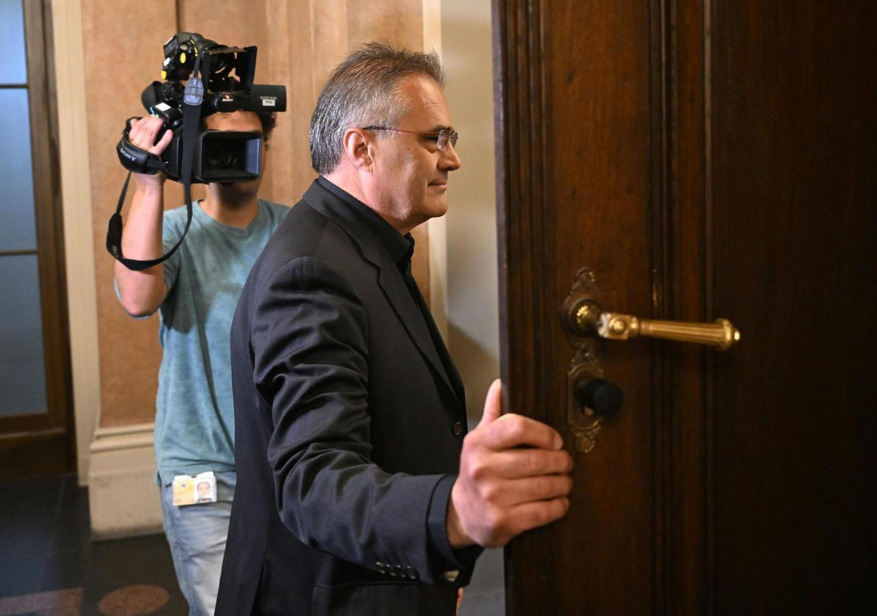 Der Ex-BVT-Beamte Egisto geht durch eine Tür am Wiener Straflandesgericht. Dahinter steht ein Kameramann.