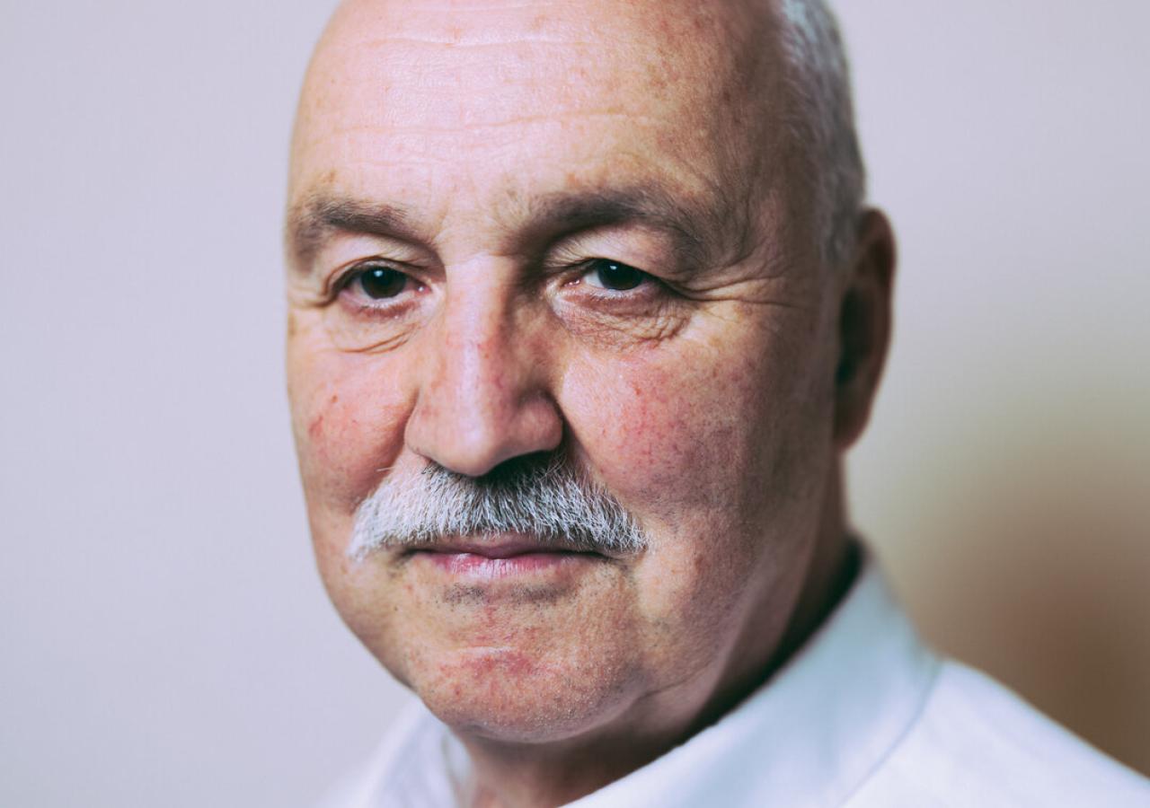 Porträt des Theologen Wolfgang Palaver vor neutralem, grau-weißem Hintergrund 