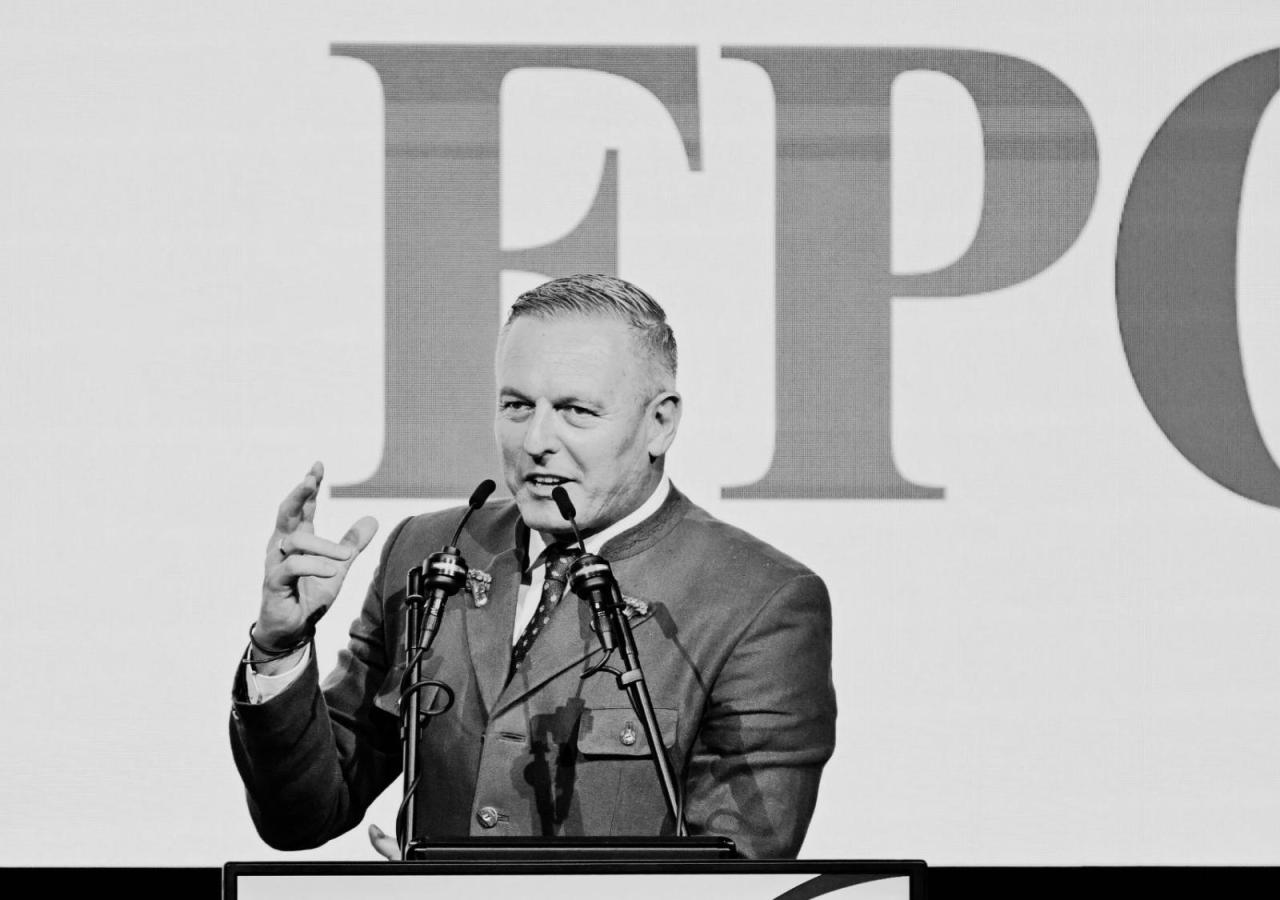 Mario Kunasek spricht bei einer FPÖ-Veranstaltung am Rednerpult vor großem FPÖ-Logo.