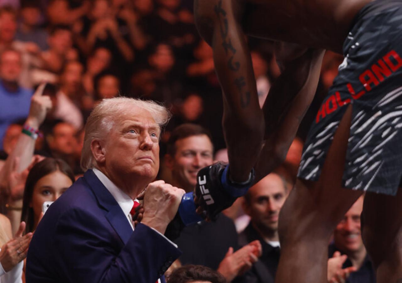 Trump schüttelt einem MMA-Kämpfer die Hand.