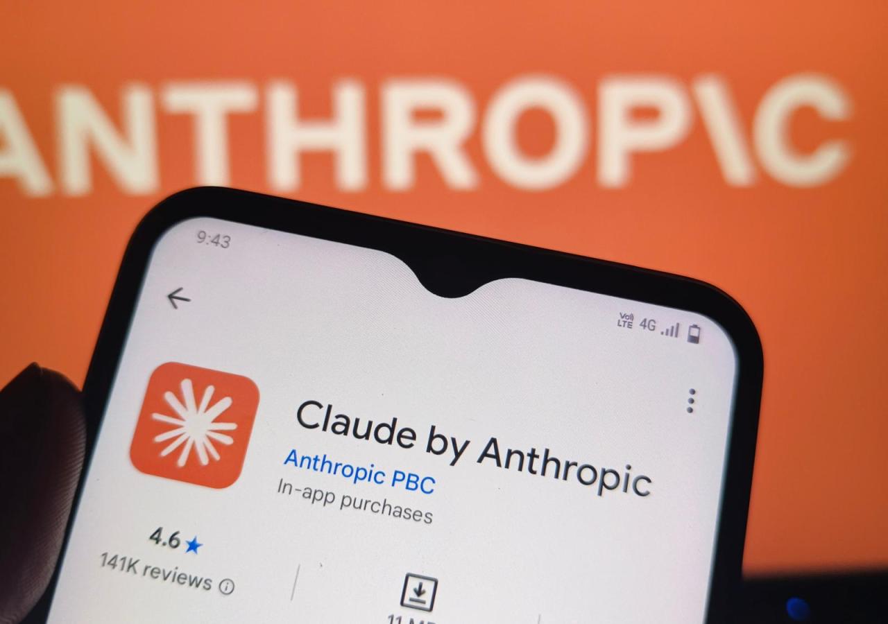 Ein Smartphone zeigt die App-Store-Seite für „Claude by Anthropic“ vor einem Hintergrund mit dem Anthropic-Logo.
