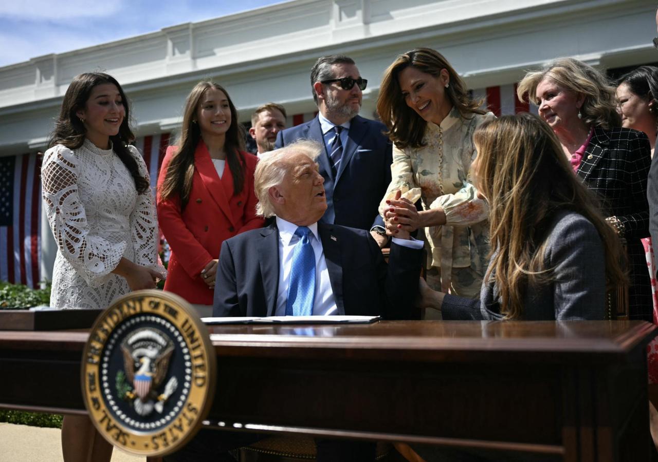 María Elvira Salazar schüttelt die Hand Trumps, der im Freien an einem Tisch sitzt.