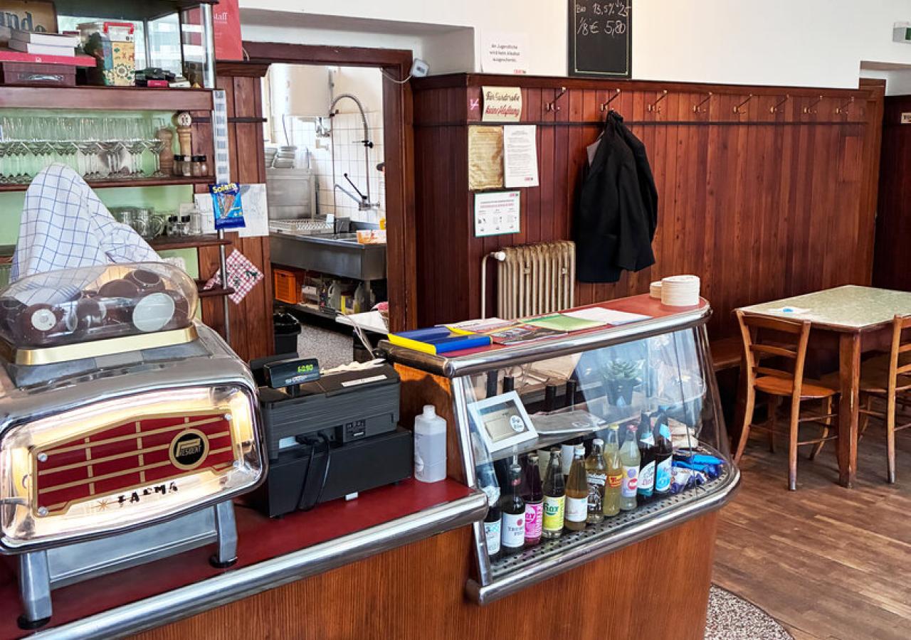 Interieur des Weinhauses Pfandler mit Schank, Holzvertäfelung und Kaffeemaschine im Vordergrund