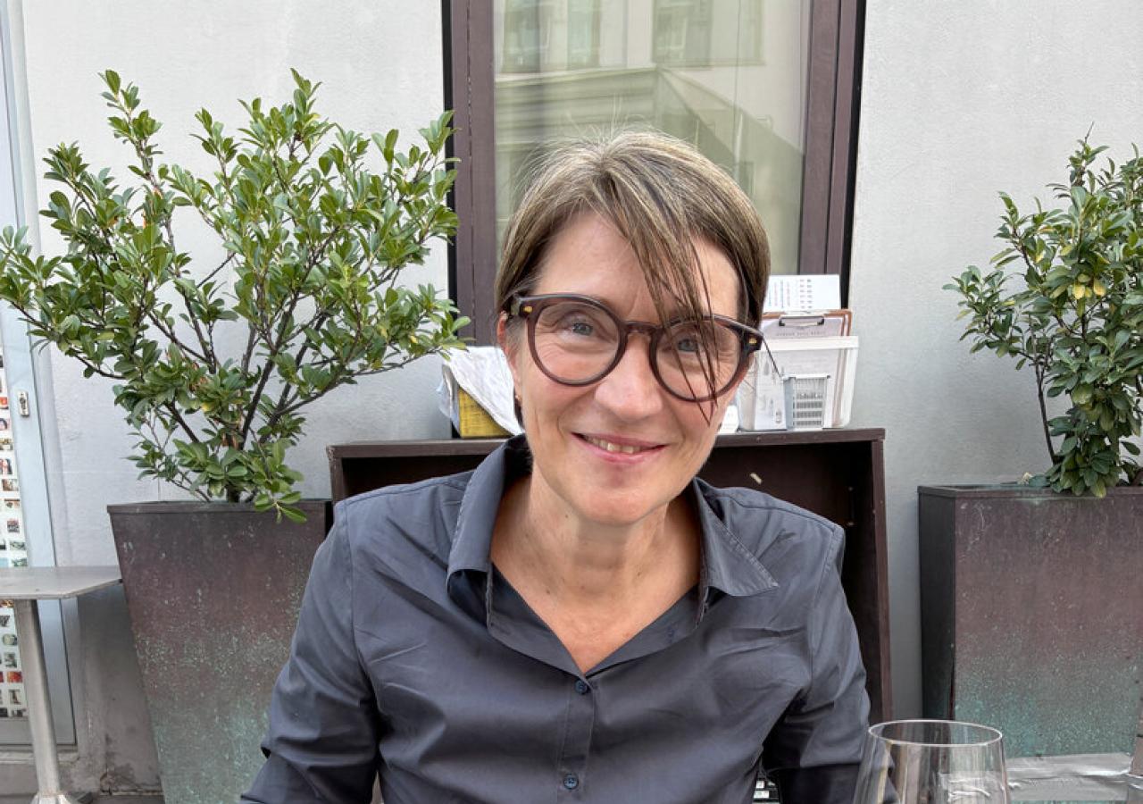 Lisa Totzauer sitzt mit Stäbchen in der Hand und schwarzem Hemd an einem Tisch