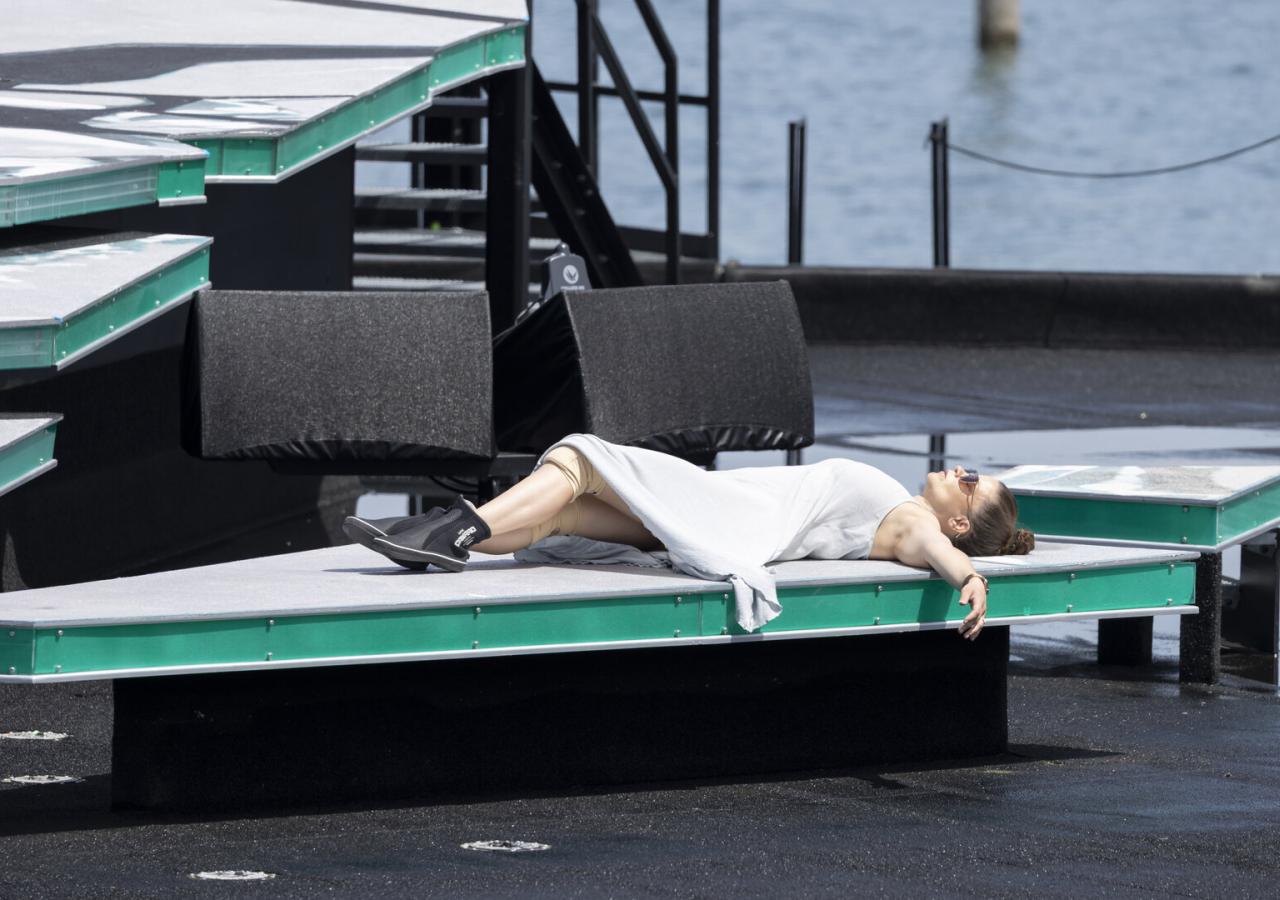 Die Sängerin Marjukka Tepponen liegt in weißem Kleid auf einem Podium während der Proben zu "La traviata".