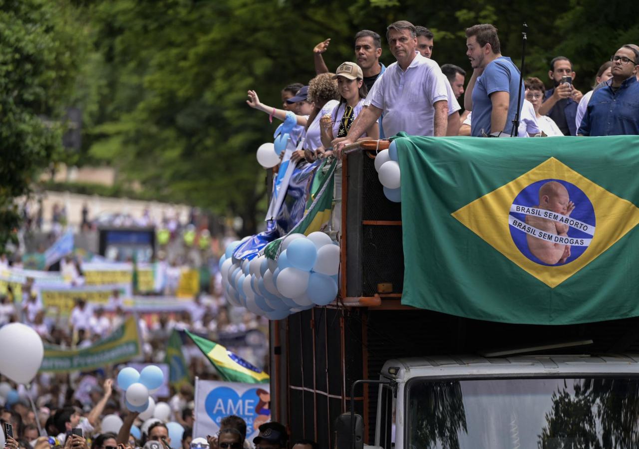 Jair Bolsonaro steht auf einem Truck mit Brasilienflagge, hinter ihm ein Menschenzug.