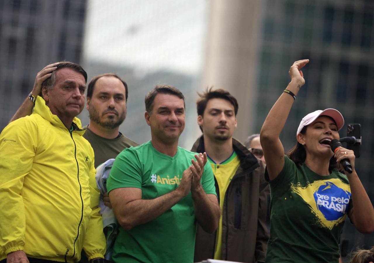 Die ganze Familie Bolsonaro steht vor einer Stadtlandschaft.