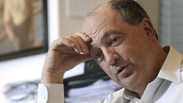 Ex-IKG-Präsident Ariel Muzicant in einem hellen Hemd stützt seinen Kopf mit der Hand.