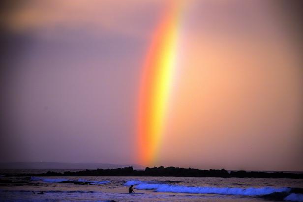 Ein Regenbogen, der bei Sonnenuntergang am Narrawallee Beach in Mollymook, etwa 224 Kilometer südlich von Sydney, hinter einem Surfer erscheint. Ein Regenbogen, der bei Sonnenuntergang am Narrawallee Beach in Mollymook, etwa 224 Kilometer südlich von Sydney, hinter einem Surfer erscheint.
