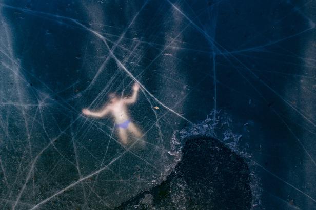 Die Luftaufnahme zeigt den finnischen Freitaucher Kristian Maki-Jussila (37), der in der Nähe von Vaasa (Finnland) unter dem Eis eines zugefrorenen Sees schwimmt. Am 21. März 2020 stellte Kristian Maki-Jussila den inoffiziellen Weltrekord des Freitauchens Die Luftaufnahme zeigt den finnischen Freitaucher Kristian Maki-Jussila (37), der in der Nähe von Vaasa (Finnland) unter dem Eis eines zugefrorenen Sees schwimmt. Am 21. März 2020 stellte Kristian Maki-Jussila den inoffiziellen Weltrekord des Freitauchens