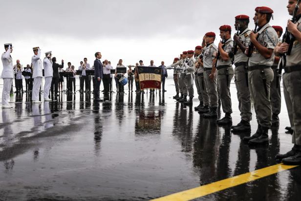 Der französische Präsident Emmanuel Macron begrüßt die Truppen, nachdem er auf dem Flughafen Saint-Denis de la Reunion auf der französischen Überseeinsel La Reunion im Rahmen einer viertägigen Reise in den französischen Überseegebieten des Indischen Ozean