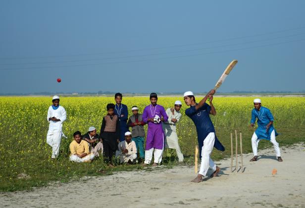 Muslimische Schüler einer religiösen Schule (Madrasa) spielen Cricket in der Nähe eines Senffeldes am Ufer des Ganges in Allahabad/Indien. Muslimische Schüler einer religiösen Schule (Madrasa) spielen Cricket in der Nähe eines Senffeldes am Ufer des Ganges in Allahabad/Indien.