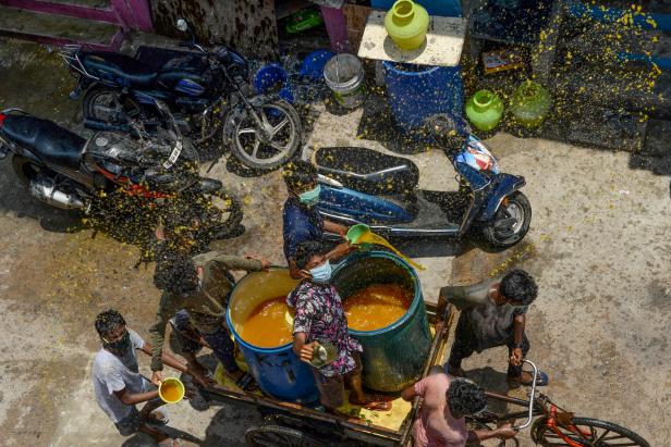 Freiwillige machen in Chennai eine Mischung aus Wasser, Neemkraut und Kurkuma als angebliches natürliches Desinfektionsmittel. Freiwillige machen in Chennai eine Mischung aus Wasser, Neemkraut und Kurkuma als angebliches natürliches Desinfektionsmittel.