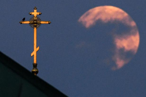 Dieses Foto zeigt den der Erde am nächsten gelegenen Supermond, auch als rosa Mond bekannt, hinter dem Kreuz einer Kirche in der Innenstadt von Moskau. Dieses Foto zeigt den der Erde am nächsten gelegenen Supermond, auch als rosa Mond bekannt, hinter dem Kreuz einer Kirche in der Innenstadt von Moskau.