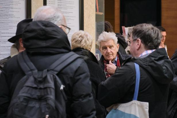 Im Getümmel der Filmwilligen: Harry Tomicek 2024, im Foyer des Filmmuseums Ein älterer Mann mit weißem Haar blickt aus einer Menschenmenge in Richtung Kamera.