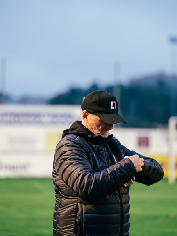 Cheftrainer Andi Ogris Andreas Ogris steht am Trainingsplatz und schaut auf seine Uhr