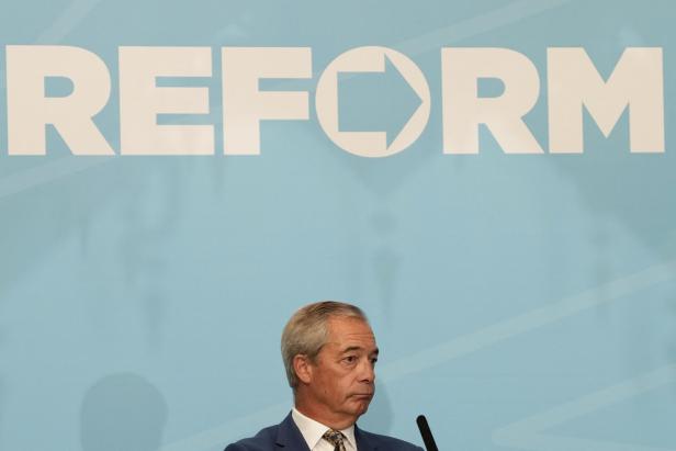 Ein Mann vor einem Plakat mit dem Wort "Reform"