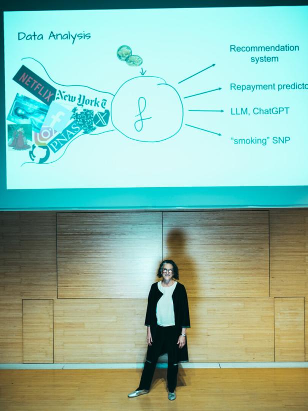 Cynthia Dwork im Vorlesungssaal vor einer Leinwand mit einer ihrer Diagramme