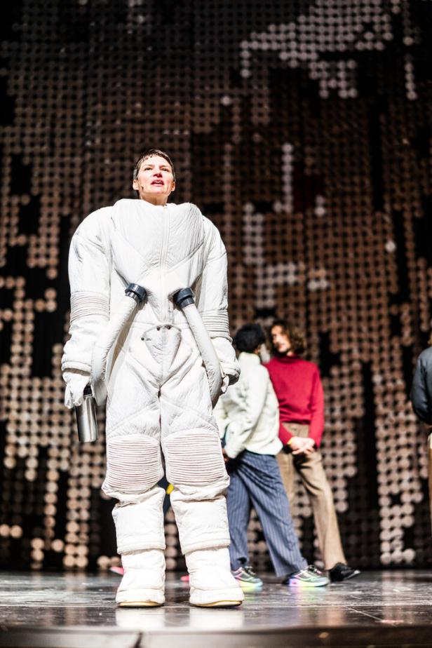 Die Schauspielerin Alicia Aumüller im weißen Astronautenanzug auf der Bühne
