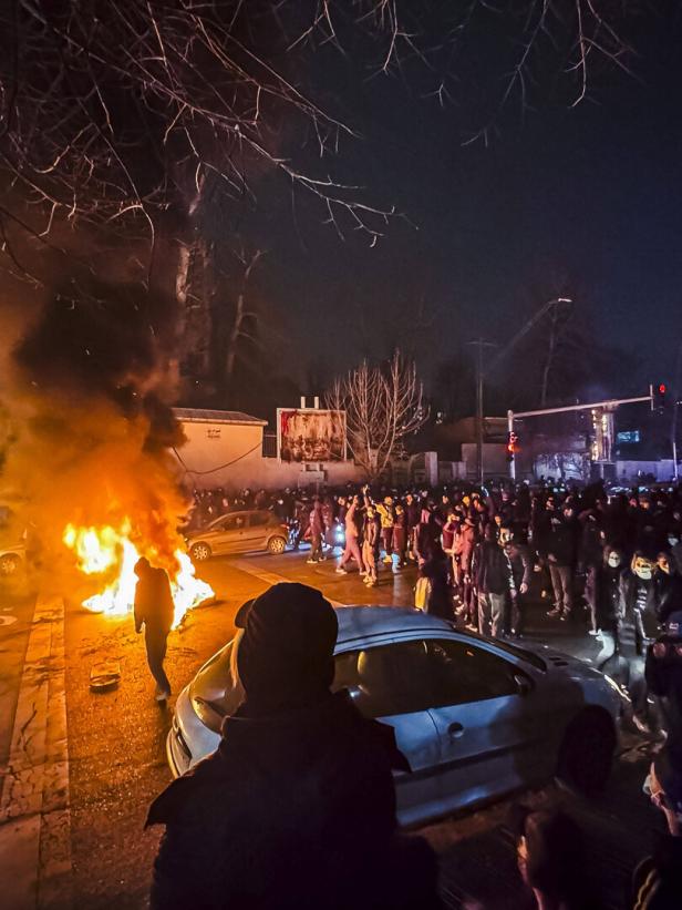 Nachtaufnahme von Demonstration auf der Straße, es brennt