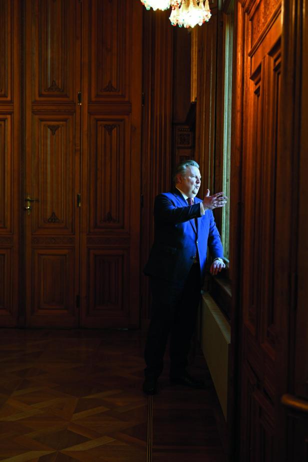 Der Wiener Bürgermeister Michael Ludwig blickt aus dem Fenster des Rathauses und gestikuliert mit der rechten Hand.