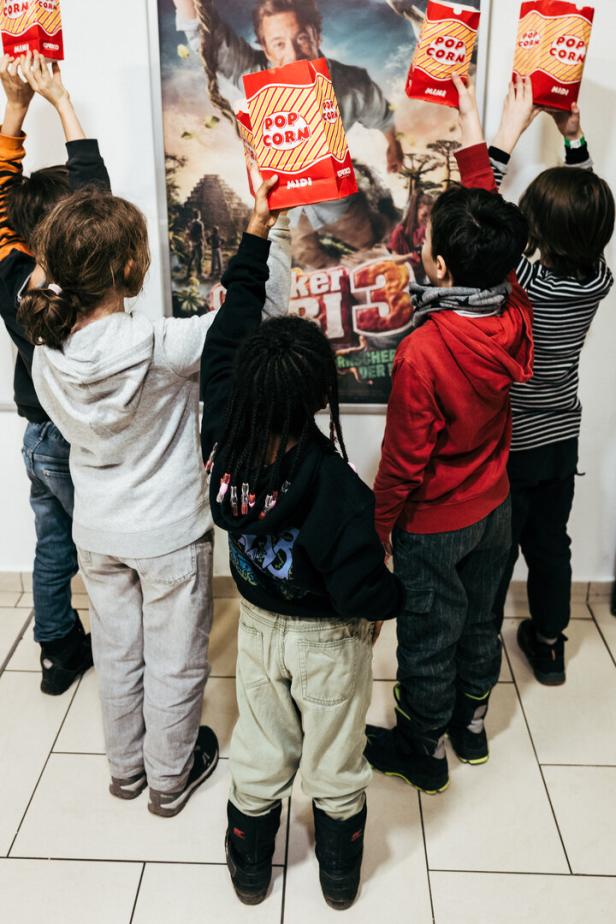 Fünf Popcorn-bewaffnete Kinder vor dem Checker-Tobi-Filmposter